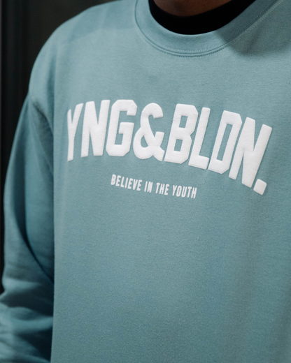 Discover elevated comfort and style with the YNG & BLDN ARCH Premium Crewneck Sweatshirt by Young and Building. Elevate your wardrobe with this high-quality, fashion-forward piece designed for the modern hustler. Upgrade your fashion game with the premium pullover in our agave blue, light teal, seafoam color with white puff print